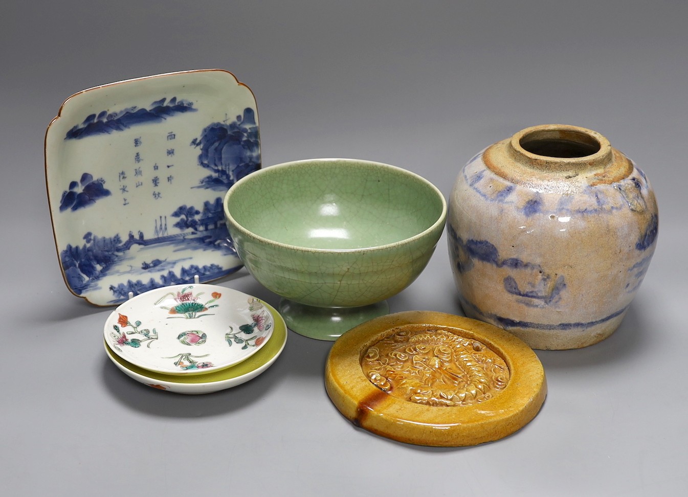 A celadon crackle glaze pedestal bowl, together with a blue and white inscribed dish, a 19th century famille verte dish and others (6)